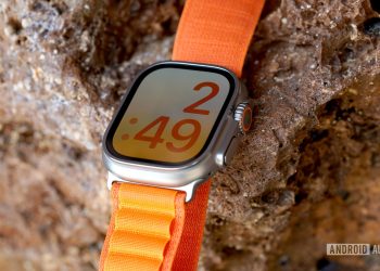 An Apple Watch Ultra rests on a rock wall displaying the X-Large watch face.